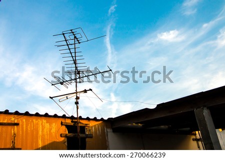 Old TV antenna on the roof and blue sky white cloud background