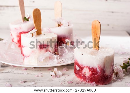 Homemade ice cream and cherry blossom branches cherries on a wooden surface in a light tone