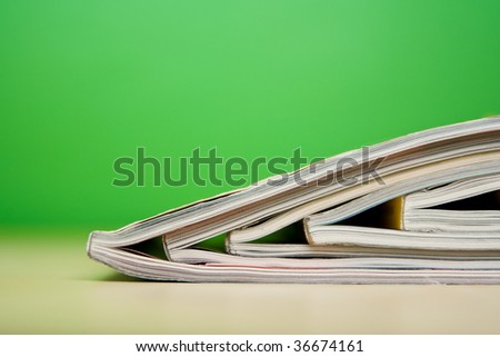 Color magazines lying on the table on green background