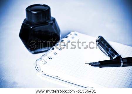 Fountain pen ink bottle and notebook in composition blue toned