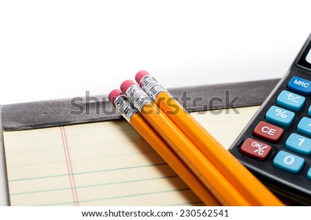 Pencil with erasers, yellow pad and calculator