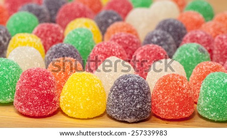 Assorted colored gum drops on a wood surface