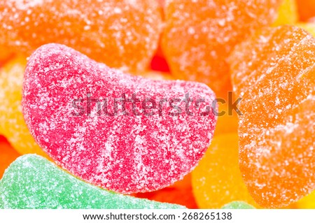 Tight image of a red fruit slice amongst a variety of other colored fruit slices.