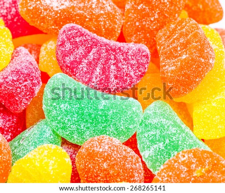 Tight image of a red fruit slice amongst a variety of other colored fruit slices.