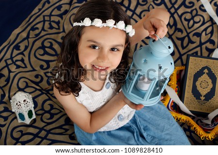 Happy young Muslim girl playing with Ramadan lantern