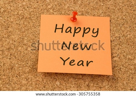 Orange sticky note on an office cork board - Happy New Year