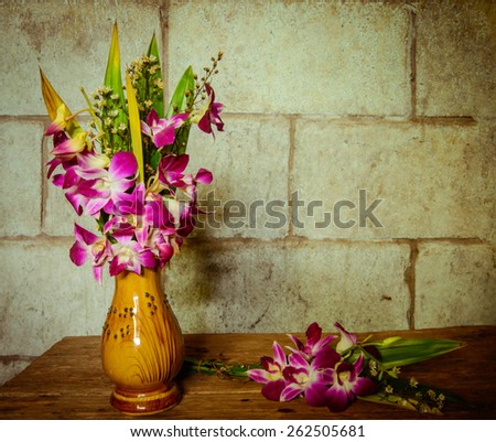 still life flowers on wood table on old brick fall background soft focus
