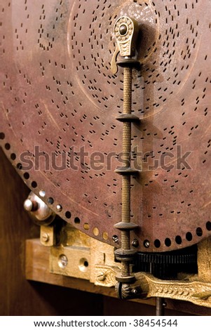 an ancient musical box, close up of disk with holes