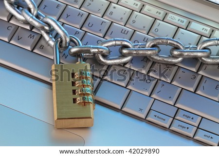 chain and digital padlock on computer keyboard, symbolizing internet security, close up fragment.
