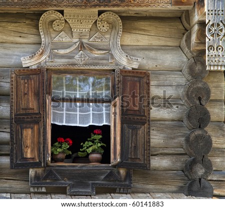 window with shutter and part of wooden wall of the  old russian  house,  with flowers on the windowsill