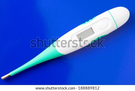 electronic thermometer on a dark blue surface