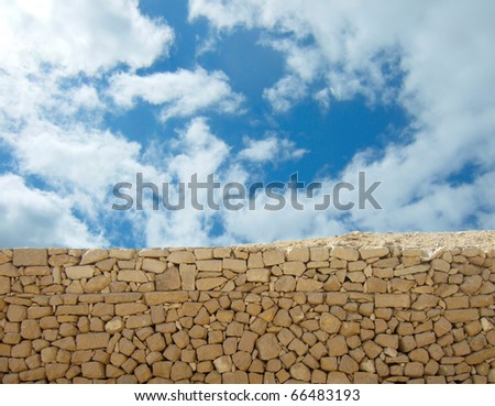 grunge old stone wall on background of blue sky