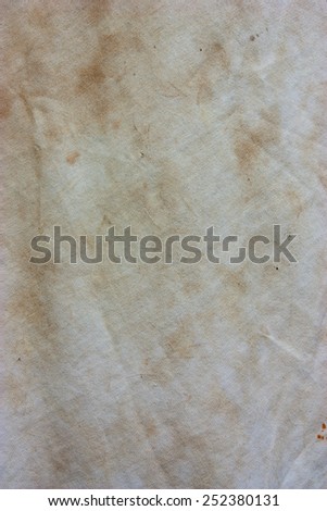 Old white fabric with a dirty stain on the surface.