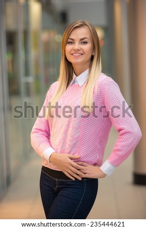 portrait of a pretty young blonde in a pink blouse on a beige background