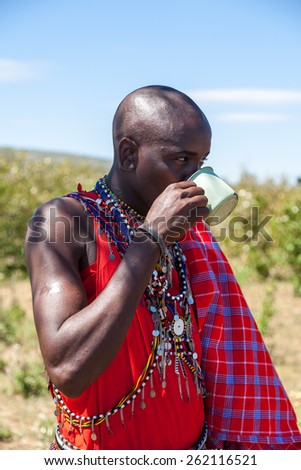 MASAI MARA,KENYA, AFRICA- FEB 12: Masai shaman  is drinking a cup of cow blood in traditional clothes, review of daily life of local people,near to Masai Mara National Park Reserve, Feb 12, 2010,Kenya