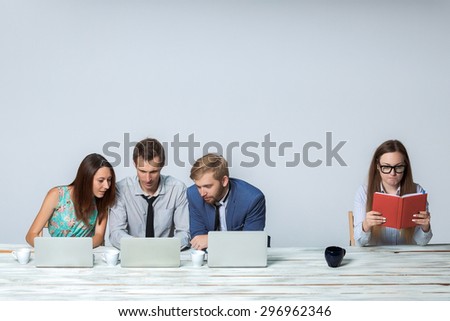 Business team working together at office on light gray background. all working on laptops. boss reading notebook. copyspace image