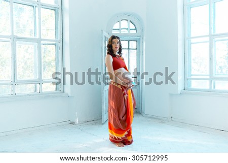 Indian picture on woman hands and pregnant belly with henna tattoo  on white room background