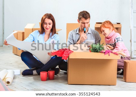 The happy family  at repair and relocation. The family planing  to accommodation on a background of boxes