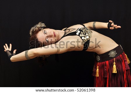 Dancer in fancy tribal skirt bending back isolated on black