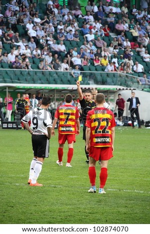 WARSAW, POLAND - APRIL 29: The referee shows a yellow card the Jagiellonia player during the match between Legia Warsaw vs Jagiellonia Bialystok on April 29, 2012 in Warsaw, Poland. Final results: 1:1