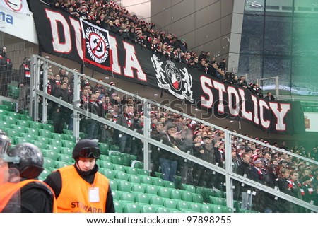 WARSAW, POLAND - MARCH 16: Fanatical fans of Polonia Warsaw during the Warsaw\'s football derby between Legia Warsaw vs Polonia Warsaw on March 16, 2012 in Warsaw, Poland. Final results: 0:0