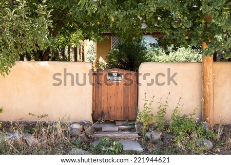 Wood gate in stucco wall no parking sign