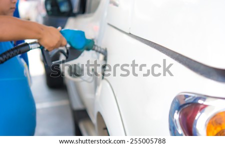Gas station pump. Man filling gasoline fuel in car holding nozzle. Blur style .