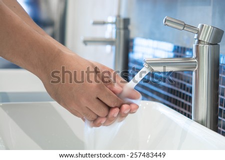 Man hands being washed under stream of pure water from tap