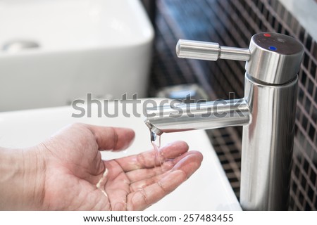Man hands being washed under stream of pure water from tap