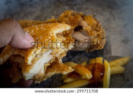 Fast food ,hamburger,fried chicken,French Fries and Human hand in Dark tone