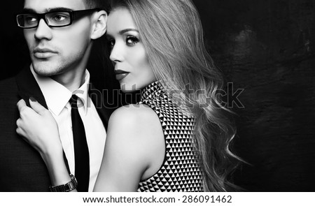 Fashion studio photo of office romance of sexy young couple of beautiful blond woman and handsome brunette businessman wearing in format suit,tie,glasses, Valentine\'s day