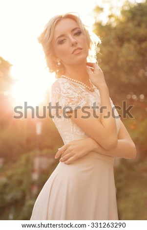fashion outdoor photo of gorgeous bride with blond hair wears luxurious dress and accessories,posing in antic villa