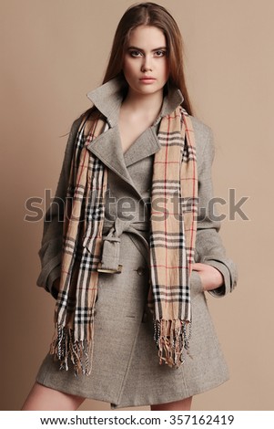 fashion studio photo of beautiful woman with dark hair in elegant wool coat