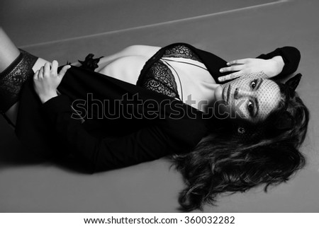 fashion studio black and white photo of beautiful woman with dark hair in elegant lace lingerie and pantyhose ,with veil on face