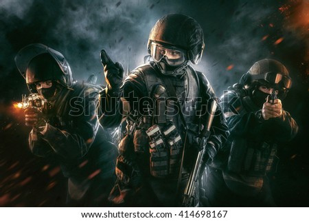 Three soldiers in full uniform with weapons is going to attack. Uniform conforms to special services FSB (soldiers) of the Russian Federation. Shot in studio. Explosion on a black background