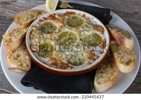 Gourmet escargot served in garlic butter sauce with garlic bread.