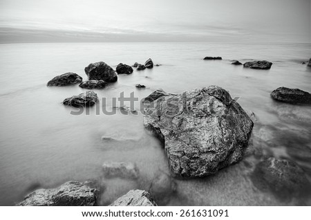 black and white photo of stones on the beach. rocks on the coast