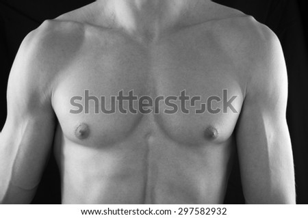 The upper body/ chest of a muscular but lean man - in black and white.