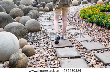 woman walk alone on way brick in public garden