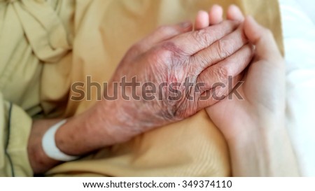 hand of old man in hospital and hold with younger hand