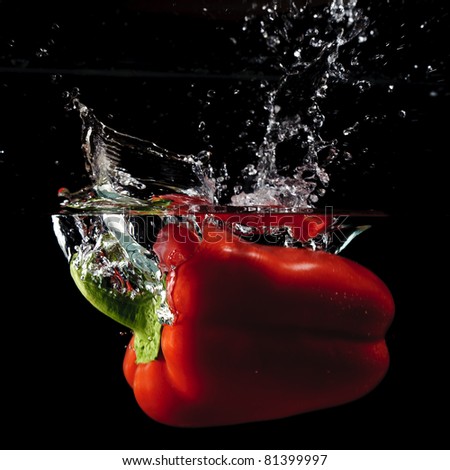 Red Pepper Splashing in water with black background