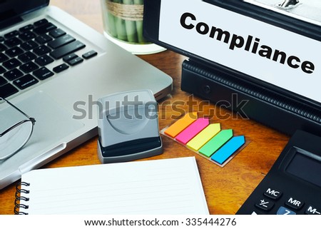 Compliance - Ring Binder on Office Desktop with Office Supplies. Business Concept on Toned and Blurred Background