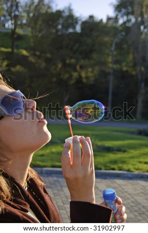 A girl inflates a soap-bubble