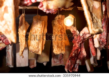 A variety of smoked meat products: ham, bacon, ribs in the smokehouse close up. Traditional way of cooking pork in eastern Europe.