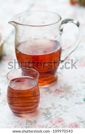 Close-up of refreshing red juice in a glass and in a jug on a table