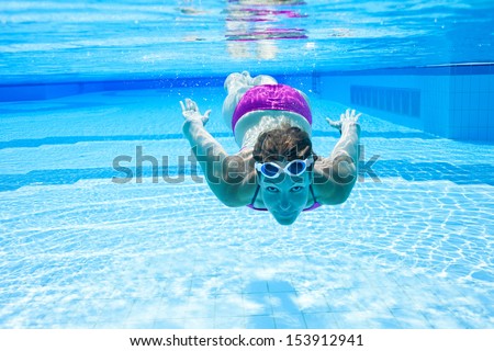 Female swimmer underwater in swimming pool with eyes open