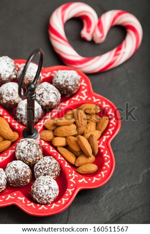 Closeup of tray of almonds and chocolate balls and hard handy heart with red swirls