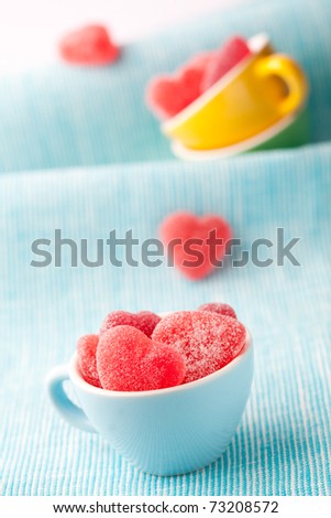 Heart shape candy in cups for Valentine's day on a light blue background