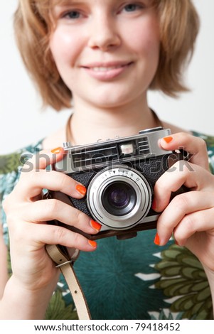 Young woman holding an old vintage camera
