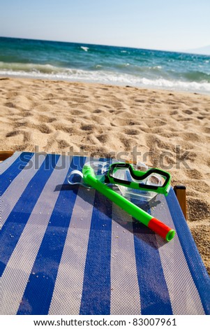 Snorkel and mask on a sunbed at the beach on a hot summer day